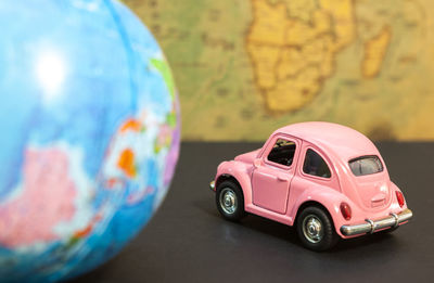 Close-up of toy car and globe on table
