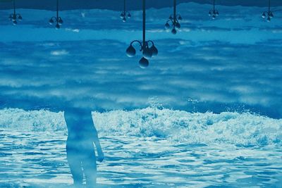 Man hanging in sea against sky