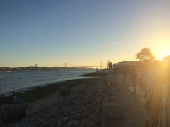 Scenic view of beach against clear sky during sunset