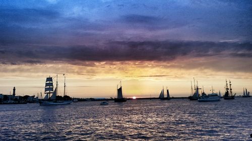 Boat sailing in sea at sunset