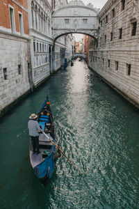 Boats in canal amidst buildings