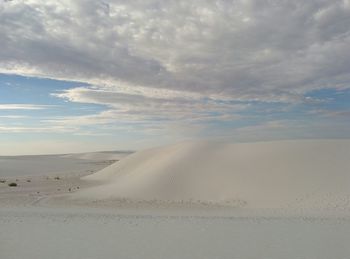 Scenic view of beach against cloudy sky