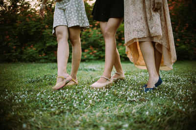 Low section of women standing on grass