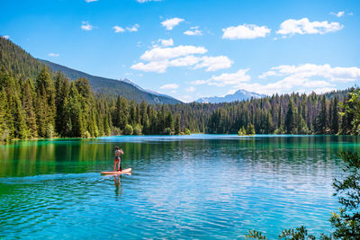 Scenic view of paddler on lake against sky