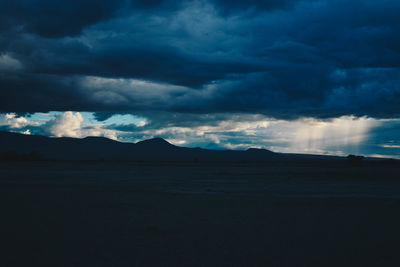 Silhouette of landscape against cloudy sky