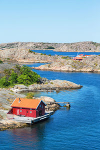 Houses by sea against clear sky