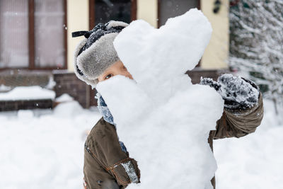 Portrait of boy with snowman