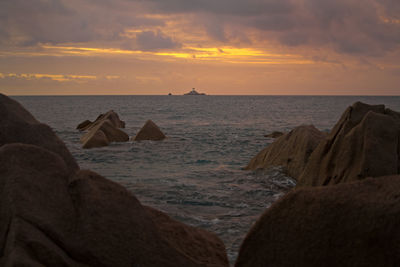 Scenic view of sea against sky during sunset among the rocks
