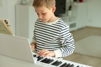 Boy playing guitar at home