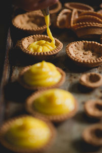 Cropped hand of chef making pastries with piping bag in bakery