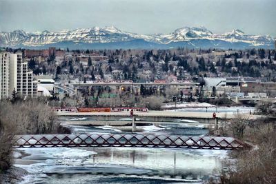 Bridge over river by mountain against sky
