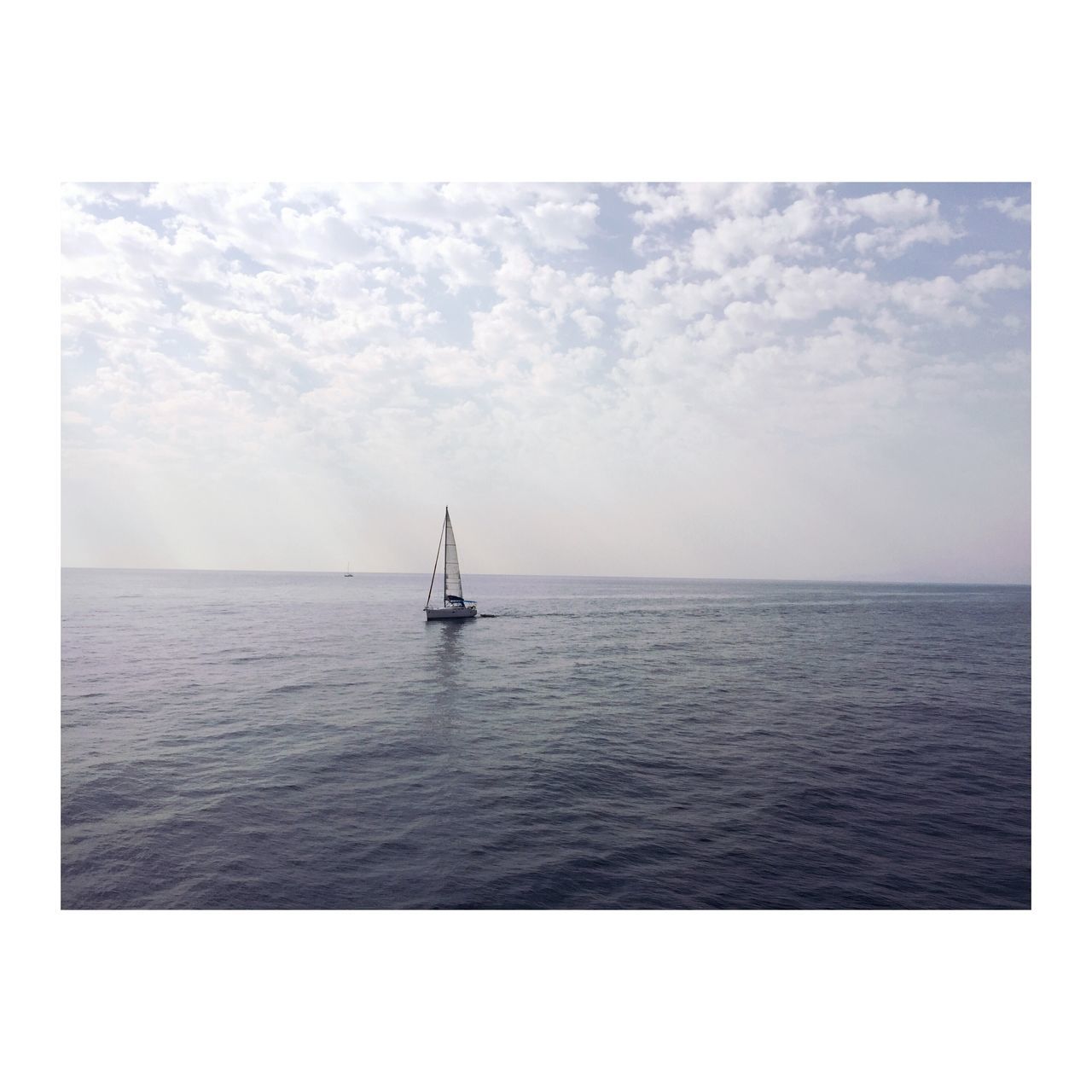 LONE BOAT IN CALM SEA AGAINST SKY