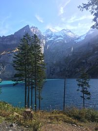 Scenic view of lake by mountains against sky