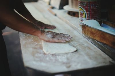 Cropped image of hand making pasta in kitchen