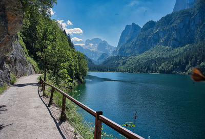 Scenic view of river by mountains against sky