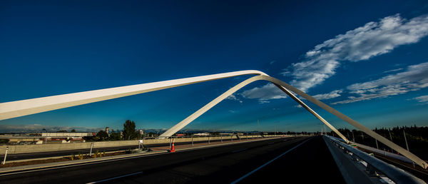 Bridge over highway against blue sky