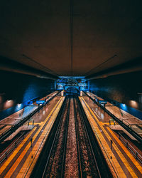Illuminated railroad tracks at night