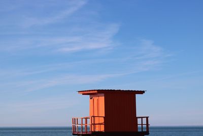 Built structure by sea against blue sky