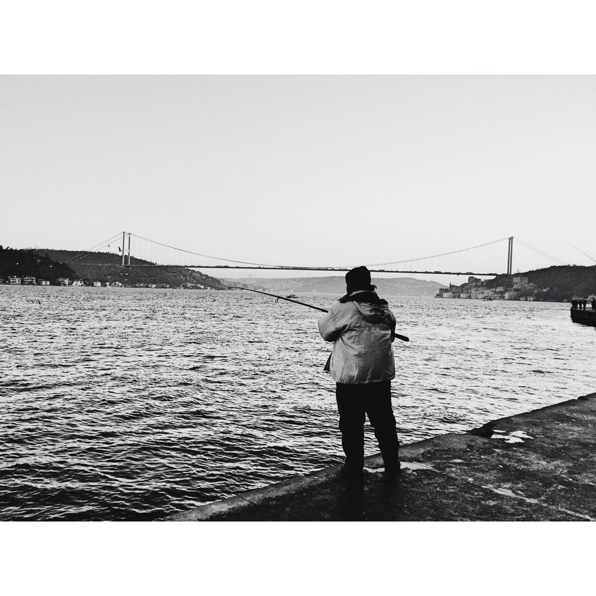 water, rear view, full length, standing, lifestyles, transfer print, leisure activity, sea, men, bridge - man made structure, connection, pier, river, built structure, walking, clear sky, railing, auto post production filter