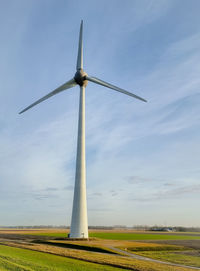 Windmill on field against sky