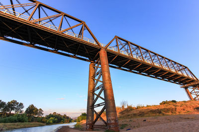 Low angle view of bridge against clear blue sky