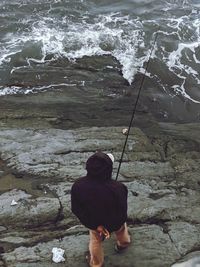 Rear view of man standing on rock