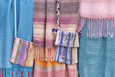 Colorful woven scarves and bags as an abstract textile background.