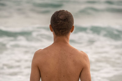 Shirtless man standing at beach