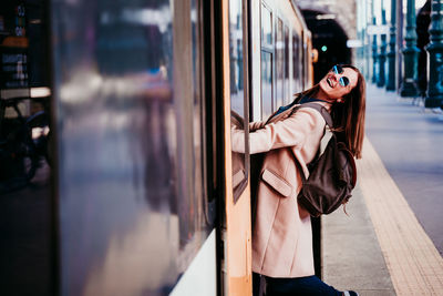 Portrait of happy woman standing in train