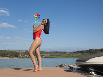 Full length of young woman standing at beach