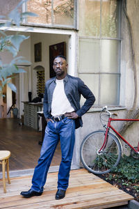 Portrait of businessman with hands on hips standing outside workplace