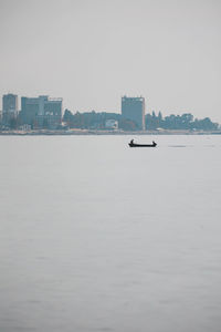 Scenic view of sea and buildings against clear sky