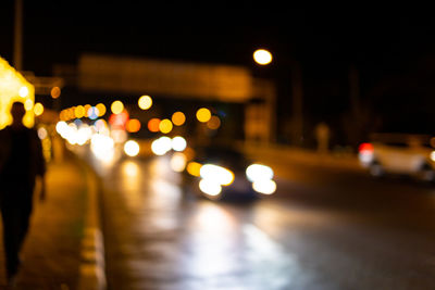 Defocused image of illuminated city street at night