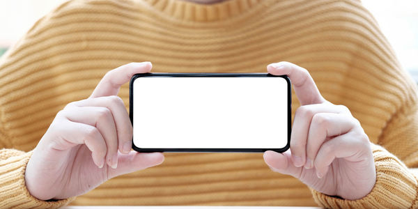 Midsection of person holding mobile phone