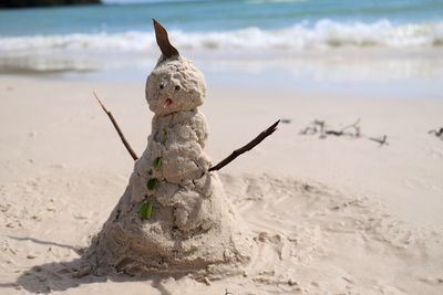 Stuffed toy on sand at beach