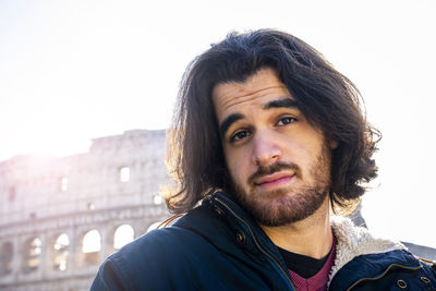 Happy moment in rome. young man posing for a photo in front of the colosseum.