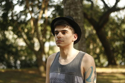 Thoughtful man in hat at forest