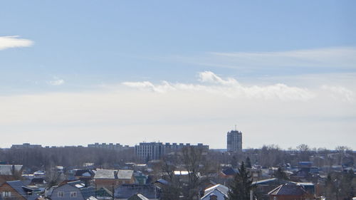 View of cityscape against cloudy sky