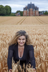 Portrait of young woman sitting on field