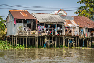 Buildings by river against clear sky