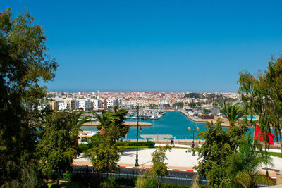 Scenic view of sea and buildings against clear blue sky