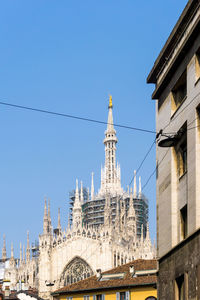 Low angle view of milan cathedral against clear blue sky