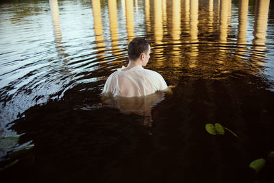 Rear view of man swimming in lake