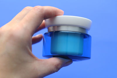 Close-up of hand holding blue glass