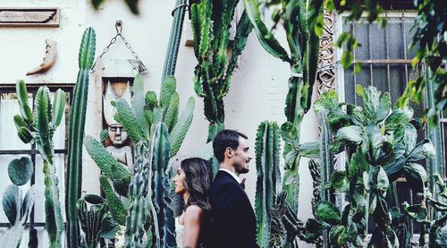 Young couple standing against plants