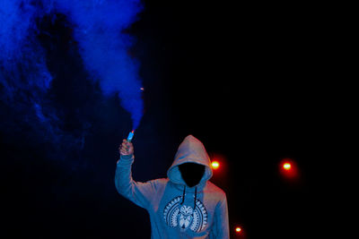 Person with smoke flare standing at night