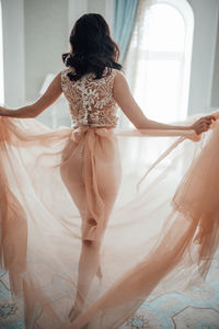 Rear view of woman wearing bridal clothing at home