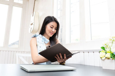 Young woman using smart phone on table
