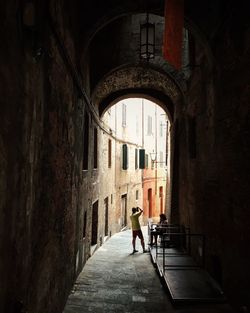 Rear view of woman walking in corridor of building