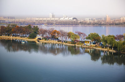 Scenic view of river by city against sky